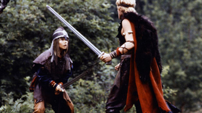 Sigurd with sword in hand looking up at a sword-wielding adult in The Littlest Viking (1989)