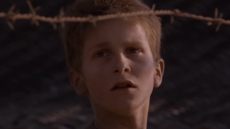 Christian Bale as Jamie behind barbed wire