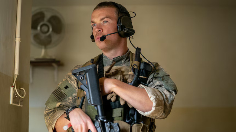 Erik holding a gun and looking at something in Warfare