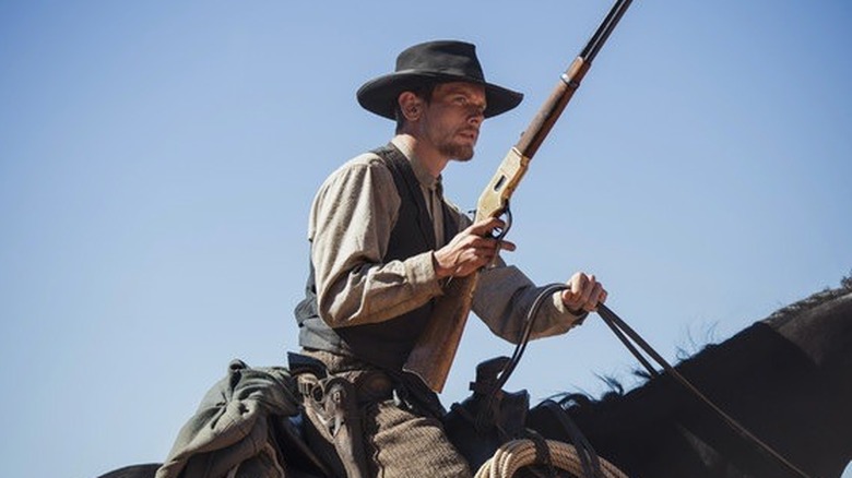 Roy on horseback holding a gun in "Godless" (2017)