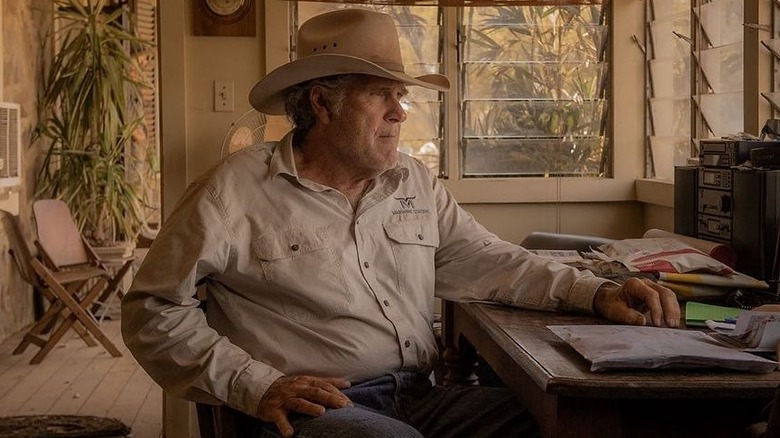 Colin sitting at a desk in "Territory" (2024)