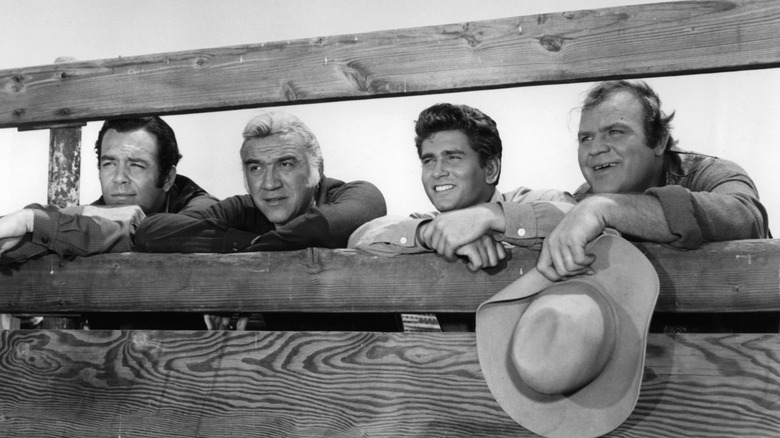 The Cartwrights, including Adam, Hoss, Joe, and Ben, looking through a fence on Bonanza (1959-1973)