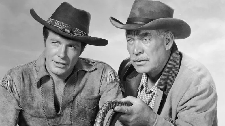 Flint McCullough stands beside Major Seth Adams looking onward on Wagon Train (1957-1965)