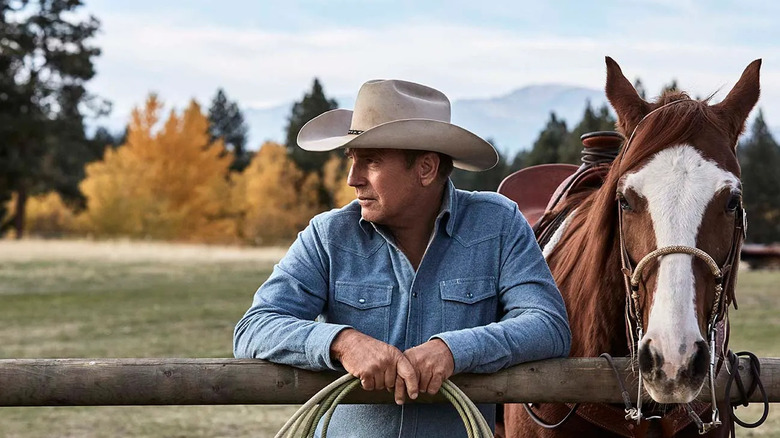 John on his ranch with a horse behind him on Yellowstone