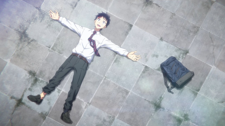 Akira lies on his back on a city street in "Zom 100: Bucket List of the Dead"