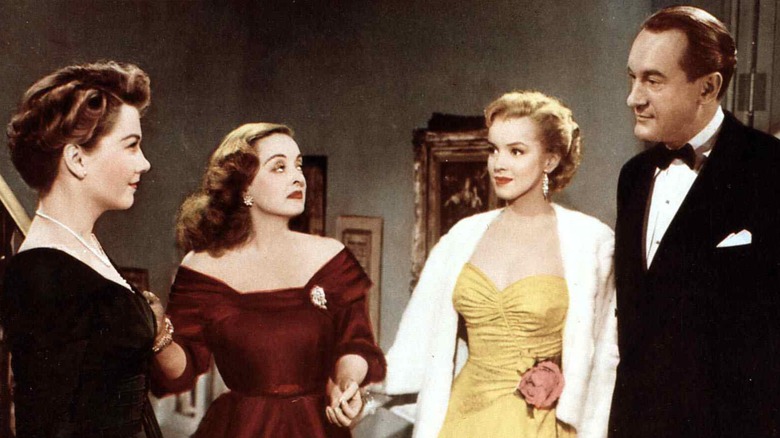 Margo, Eve, Claudia, and man look at each other