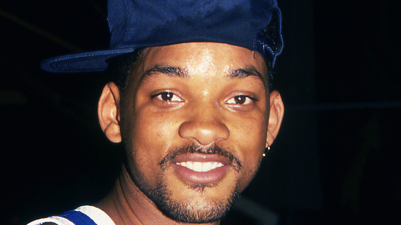 Will Smith wears hat and stares at camera