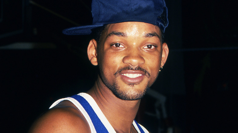 Will Smith wears hat and stares at camera