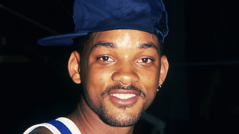 Will Smith wears hat and stares at camera