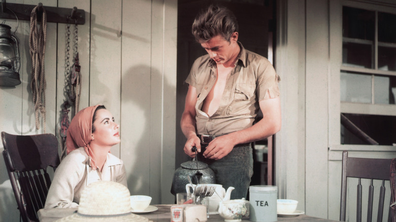 Leslie (Elizabeth Taylor) seated at a table and looking up at Jett (James Dean) in "Giant" (1956)