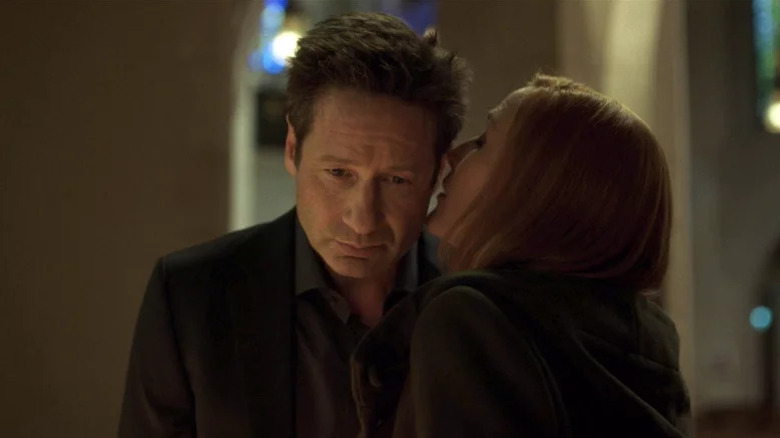 Scully whispering in Mulder's ear in "The X-Files"