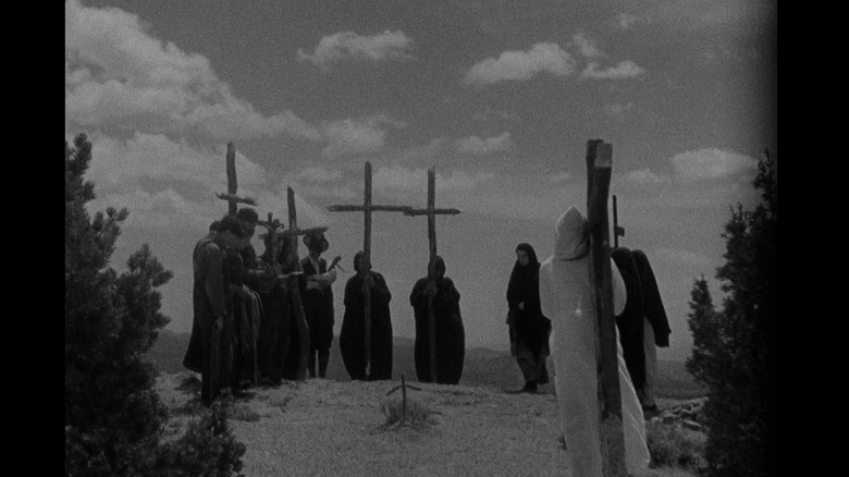 Penitentes stand near crucifixes