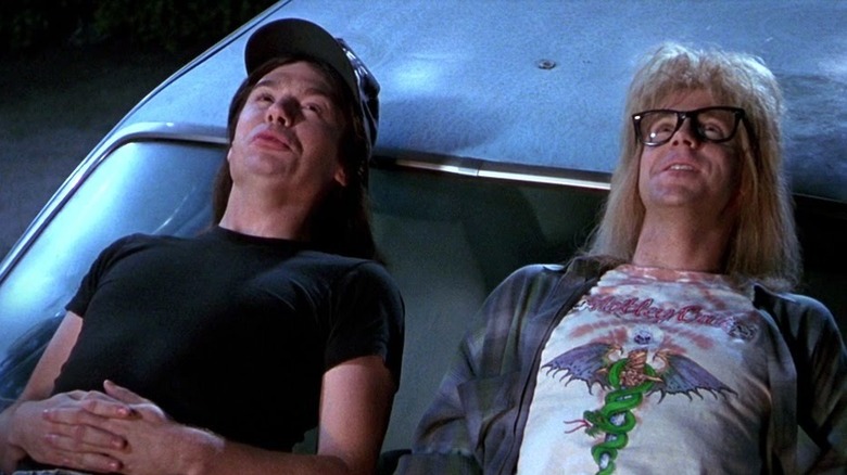 Wayne and Garth sitting on a car hood