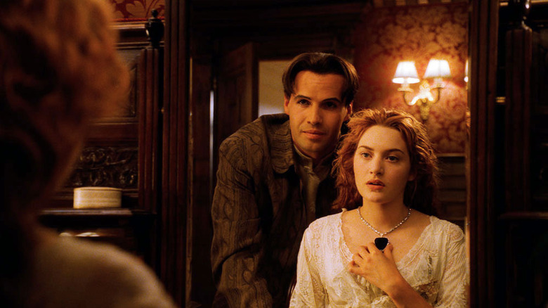 Rose and Caledon Hockley look in mirror at necklace she wears