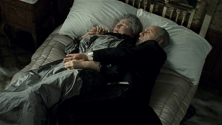 Old couple holds each other in sinking bed