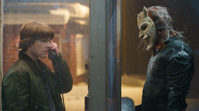 Finney on pay phone while the Grabber looks on in Black Phone 2