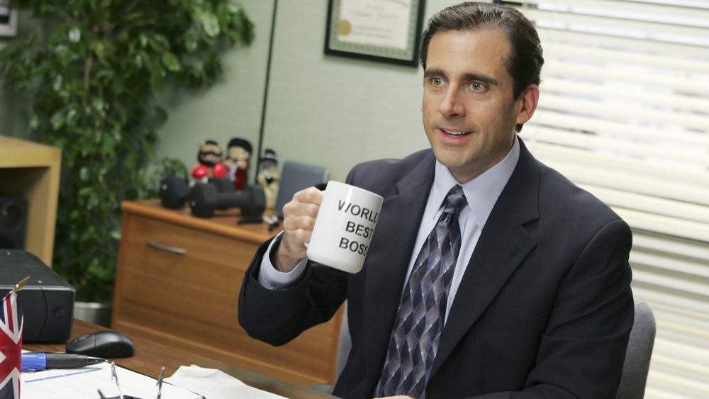 Steve Carell raising a World's Best Boss mug as Michael Scott in The Office