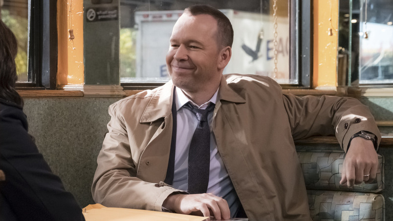 Danny Reagan smiling sitting in booth