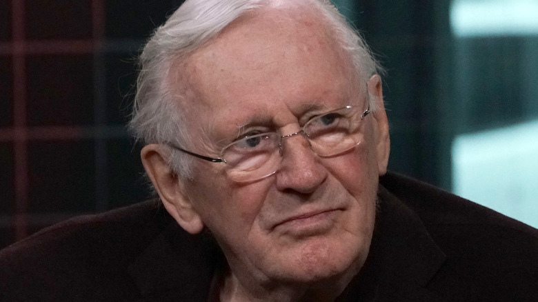 Len Cariou wearing glasses looking to the side