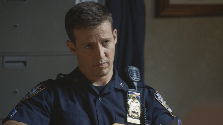 Will Estes sits behind a desk