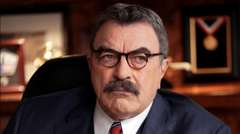 Tom Selleck glares under glasses