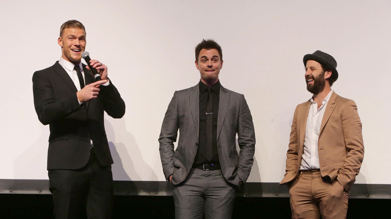 Alan Ritchson, Darin Brooks, and Romanski in suits talking at panel discussion