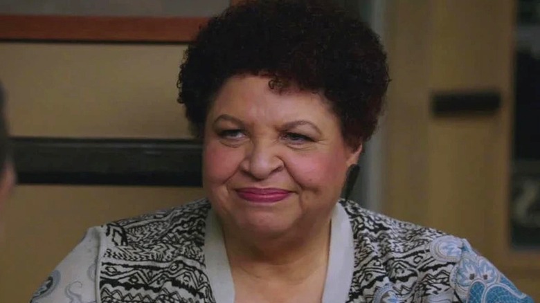 Caroline smiles sitting at a table in Bones