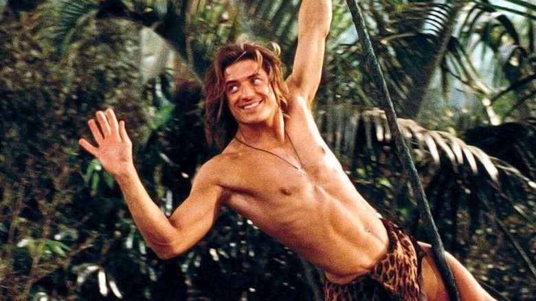 Man in loincloth swinging from tree