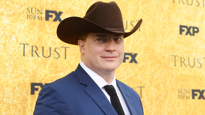 Brendan Fraser in a blue suit and brown cowboy hat