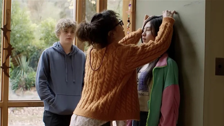Laura measures Piper on a wall as Andy stands by windows in "Bring Her Back" (2025)