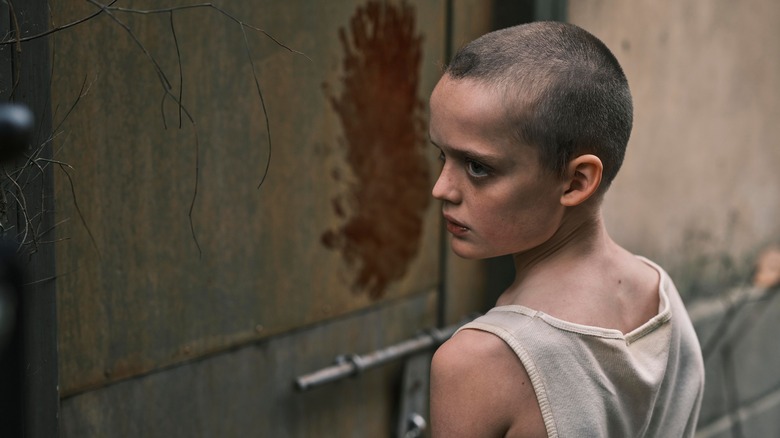 Oliver standing by wall with bloody hand smears on it in "Bring Her Back" (2025)