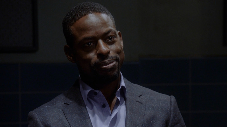 Dentist and murder suspect Philip sitting in the interrogation room wearing a casual suit and a confident smirk