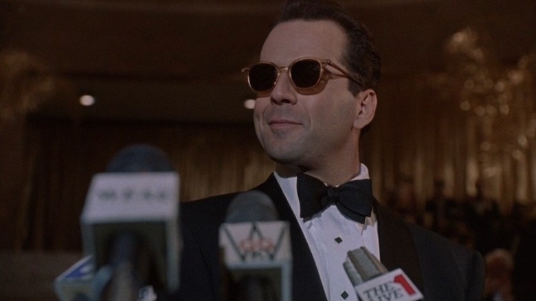 Peter smiles surrounded by microphones in "The Bonfire of the Vanities" (1990)