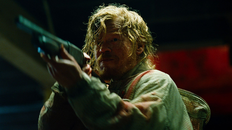 Teddy aims a gun in "Bugonia" (2025)