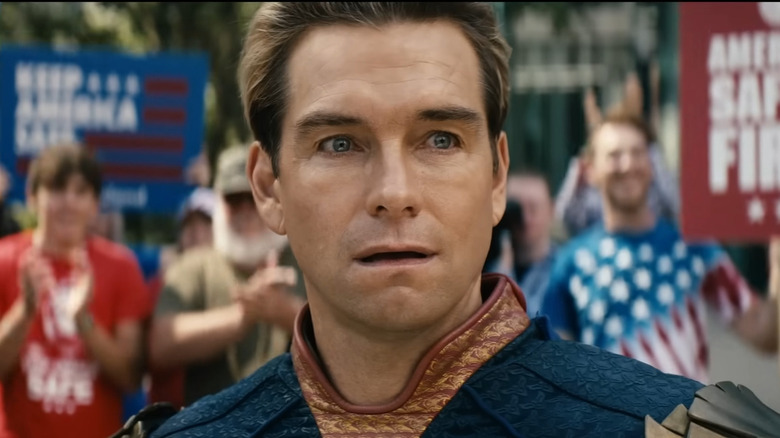 Homelander stands in front of a rally of protestors