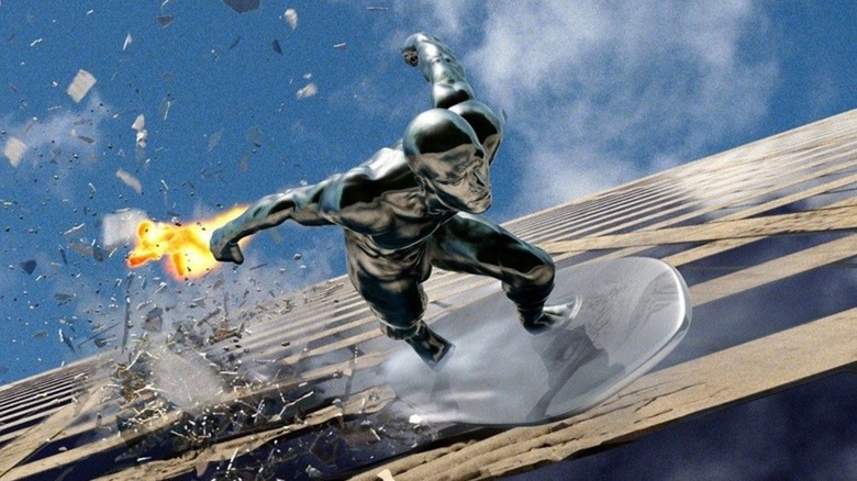 The Silver Surfer riding his board over a skyscraper with the Human Torch in hot pursuit