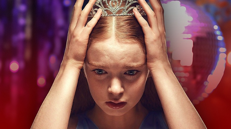 Carrie holding the crown on her head and looking aghast on Carrie