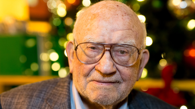 Ed Asner in front of holiday lights