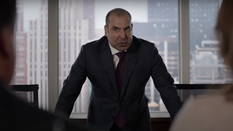 Louis Litt glaring over desk