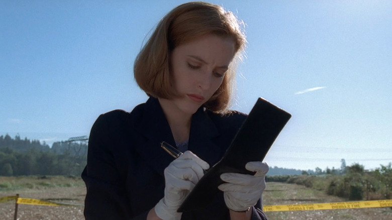 Scully writing in notepad 