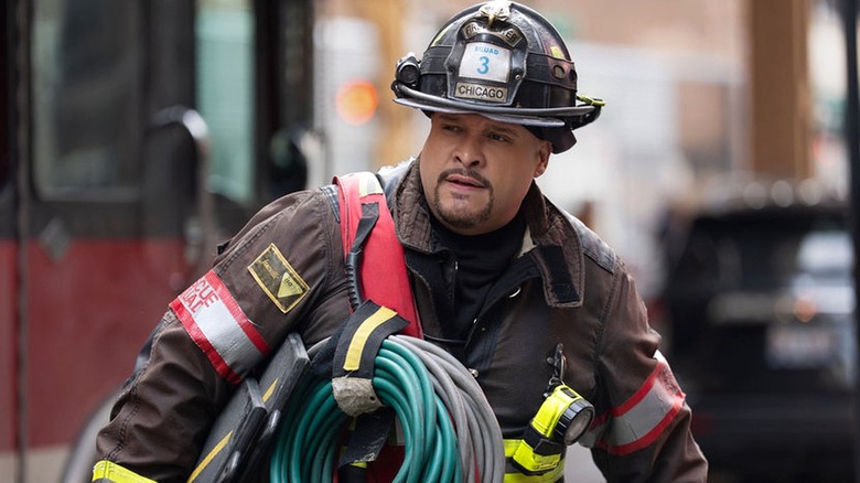 Cruz walking with a hose looped over his shoulder in 