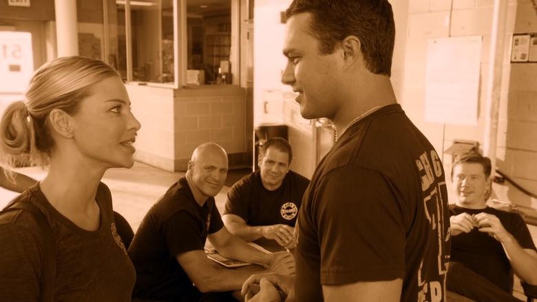 Taylor Kinney and Lauren German face each other