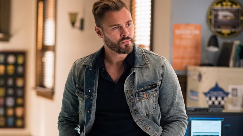 Adam Ruzek listening in a denim jacket in "Chicago PD"