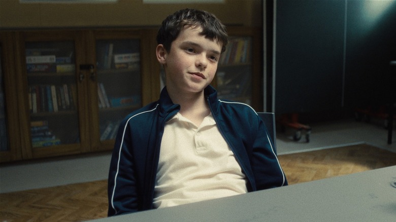 Jamie sitting in interrogation room smirking