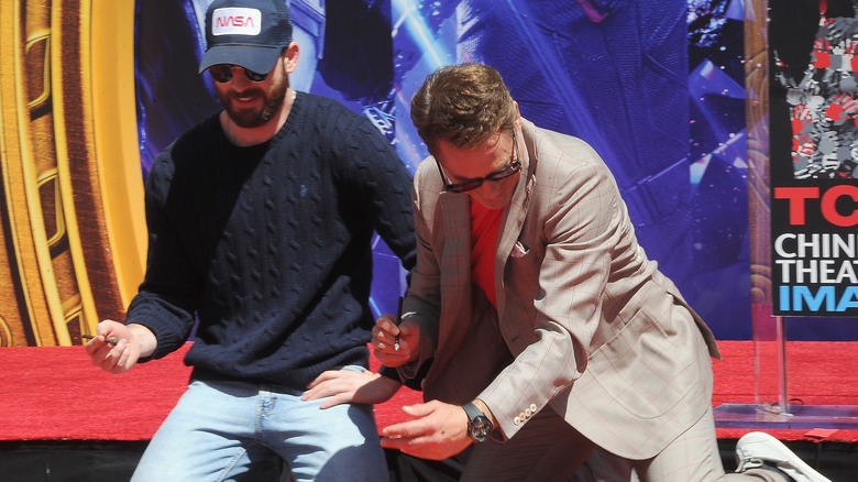 Chris Evans and Robert Downey Jr. imprinting their hands on the Walk of Fame