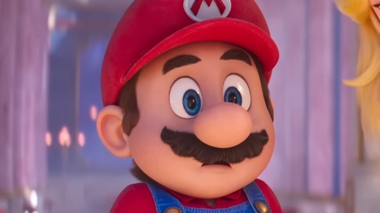 Mario looks surprised while standing in front of light pink background