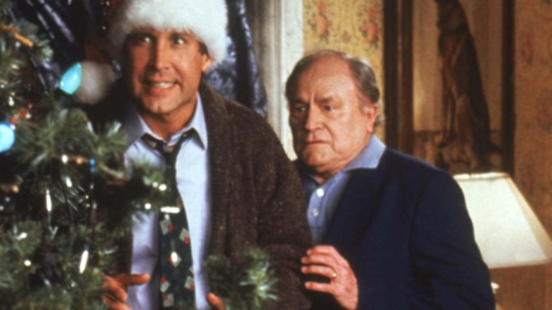 Clark Griswold and Art Smith hiding behind Christmas tree in National Lampoon's Christmas Vacation (1983)