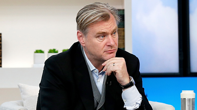 Christopher Nolan sitting in a chair