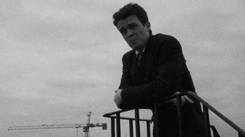 Young man standing against railing