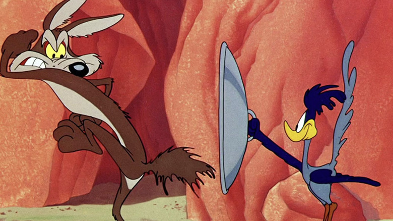 Roadrunner holds up a shield to Wile E. Coyote